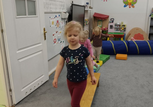 dzieci pokonują tor przeszkód po ławeczce