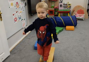 dzieci pokonują tor przeszkód po ławeczce