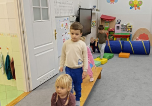 dzieci pokonują tor przeszkód po ławeczce