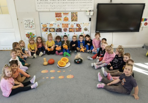 grupa dzieci pozuje przy rozkrojonej dyni do zdjęcia