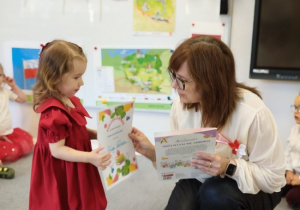 Pani Ewa wręcza dziewczynce dyplom i książkę