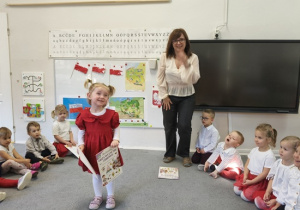 Pani Ewa wręcza dziewczynce książkę i dyplom