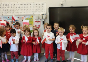 dzieci w strojach biało- czerwonych z flagami