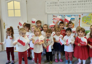 dzieci w strojach biało- czerwonych z flagami w rękach