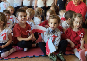 dzieci w strojach biało- czerwonych w rękach trzymają flagi