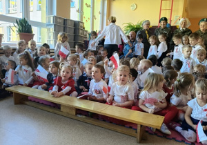 dzieci w strojach biało- czerwonych w rękach trzymają flagi