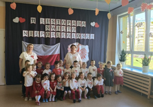 dzieci w strojach biało- czerwonych pozują z wychowawczyniami do zdjęcia