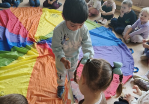 chłopiec rozdaje dzieciom cukierki