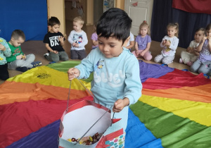 chłopiec częstuje dzieci cukierkami