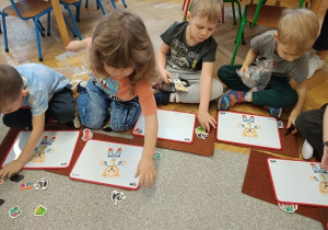 dzieci układają magnetycznego misia na tabliczce magnetycznej
