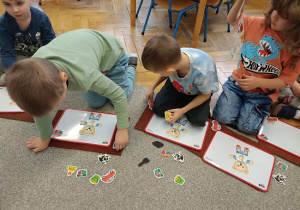 dzieci układają magnetycznego misia na tabliczce magnetycznej