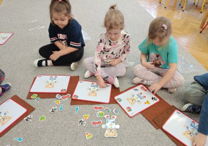 dzieci układają magnetycznego misia na tabliczce magnetycznej