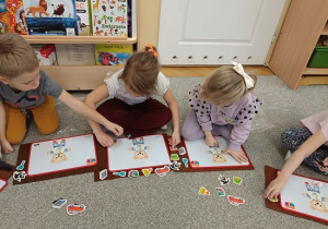dzieci układają magnetycznego misia na tabliczce magnetycznej