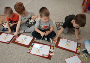 dzieci układają magnetycznego misia na tabliczce magnetycznej