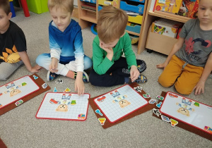 dzieci układają magnetycznego misia na tabliczce magnetycznej
