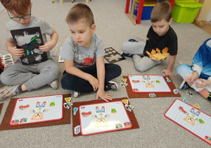 dzieci układają magnetycznego misia na tabliczce magnetycznej