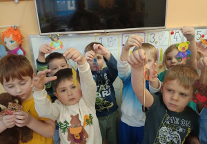 dzieci prezentują pokolorowane mazakami misie