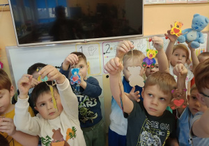 dzieci prezentują pokolorowane mazakami misie