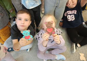 dzieci prezentują pokolorowane mazakami misie