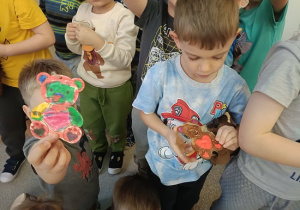 dzieci prezentują pokolorowane mazakami misie