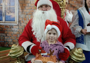 dziewczynka z prezentem w obecności Mikołaja