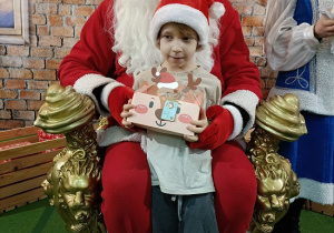 chłopiec z prezentem w obecności Mikołaja
