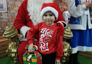 chłopiec z prezentem w obecności Mikołaja