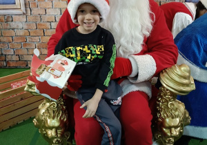 chłopiec z prezentem w obecności Mikołaja