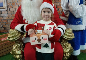 dziewczynka z prezentem w obecności Mikołaja