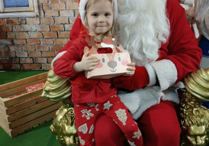 dziewczynka z prezentem w obecności Mikołaja