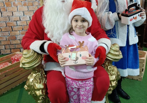 dziewczynka z prezentem w obecności Mikołaja