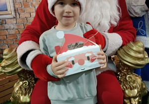 chłopiec z prezentem w obecności Mikołaja