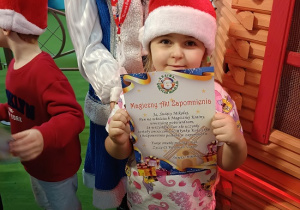 dziewczynka w czapce Mikołaja z dyplomem