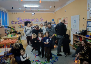 dzieci wspólnie z rodzicami biorą udział w zabawach andrzejkowych