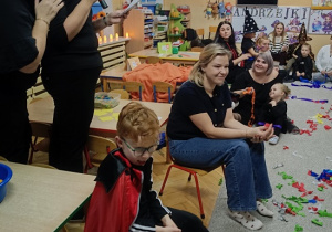 dzieci wspólnie z rodzicami biorą udział w zabawach andrzejkowych