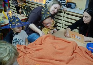 dzieci losują przedmioty spod koca