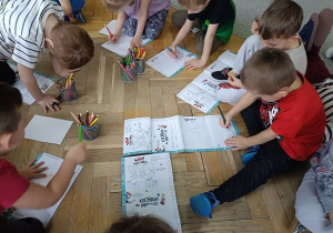 dzieci na podłodze rysują rysunki, listy do św. Mikołaja