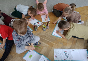dzieci na podłodze rysują rysunki, listy do św. Mikołaja