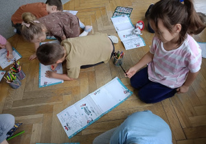 dzieci na podłodze rysują rysunki, listy do św. Mikołaja
