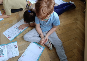 dzieci na podłodze rysują rysunki, listy do św. Mikołaja