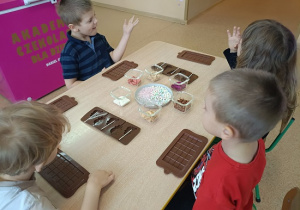 dzieci przygotowują sylikonowe foramki na czekoladę