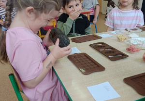 dzieci dotykają i wąchają owoc kakaowca