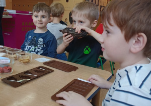 dzieci dotykają i wąchają owoc kakaowca