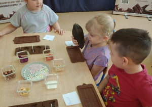 dzieci dotykają i wąchają owoc kakaowca