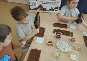 dzieci dotykają i wąchają owoc kakaowca