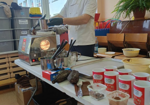 Pan nalewa gorącą czekoladę do kubeczka