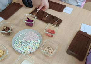 dzieci dekorują czekoladowe lizaki