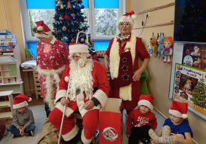 Mikołaj, Panie przebrane za śnieżynki i dzieci w czapkach mikołajkowych