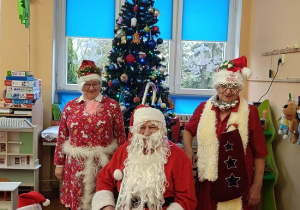 Mikołaj, Panie przebrane za śnieżynki i dzieci w czapkach mikołajkowych