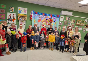 dzieci z prezentami i seniorami pozują do zdjęcia